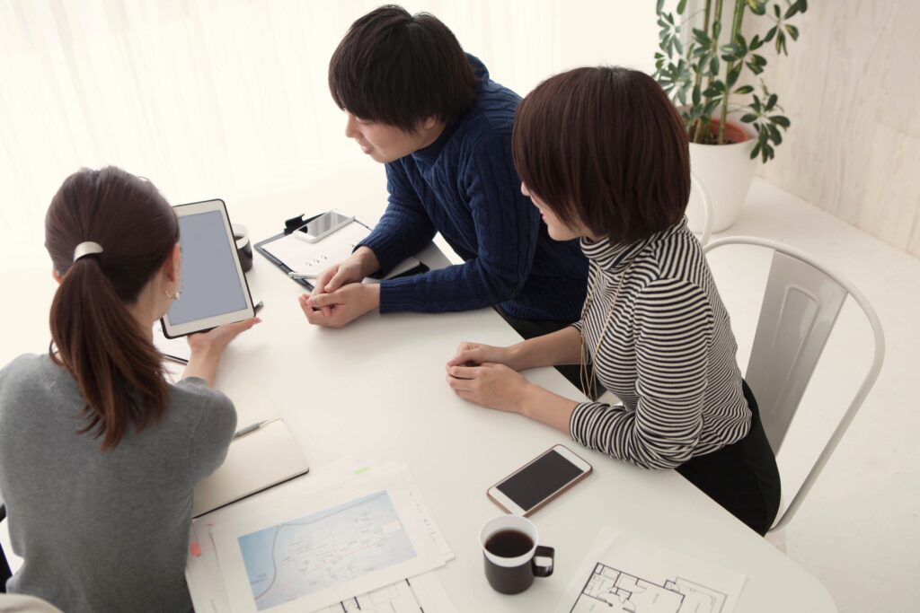 コンサルタントと若い夫婦がiPadを見ながら水回りリフォームについて相談している様子