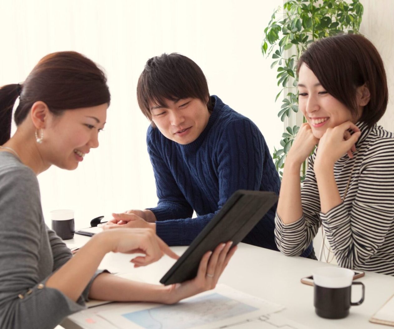 iPadを見ながら水回りリフォームについて相談する夫婦とコンサルタント