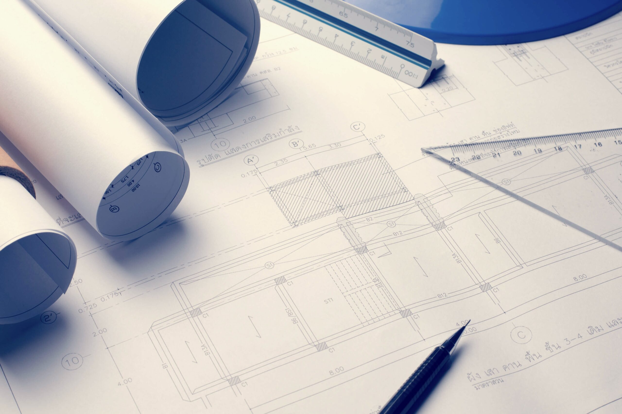 設計図と製図道具を使ってリフォーム計画を検討するイメージ